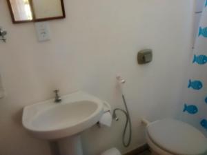 a bathroom with a sink and a toilet at Pousada Do Caju in Nova Viçosa