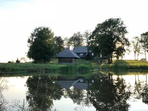 uma casa numa colina ao lado de um lago em Boutique Country house - Aliteni em Tētītes