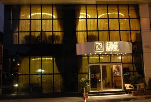 a front view of a building at night at Pınar Elite Hotel in Adana