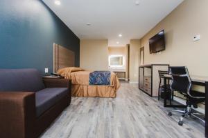 a bedroom with a bed and a desk and a couch at Budget Host Inn & Suites in Four Corners
