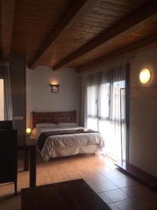 a bedroom with a bed and a large window at Casa Salto de Roldán in Apiés