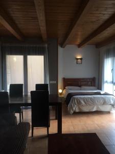 a bedroom with a bed and a table and a desk at Casa Salto de Roldán in Apiés