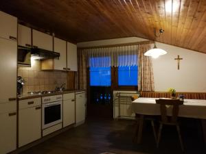 a kitchen with a table and a cross on the wall at Bauernhof Bethuber in Matrei in Osttirol