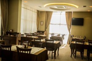 ein Restaurant mit Tischen und Stühlen und einem großen Fenster in der Unterkunft ferhane hotel in Adana