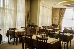 ein Esszimmer mit Tischen, Stühlen und Fenstern in der Unterkunft ferhane hotel in Adana