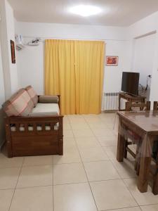 uma sala de estar com um sofá e uma mesa em Zelarrayan 456 con cochera propia em Bahía Blanca