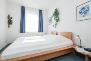 a bedroom with a bed and a desk and a window at 17 Dünenweg Dünenblick in Boltenhagen