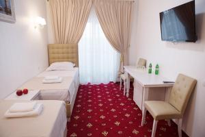 a hotel room with two beds and a desk at Bavaria in Hatne