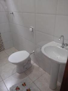 a bathroom with a toilet and a sink at Pousada e camping Canastra Mineira in São Roque de Minas