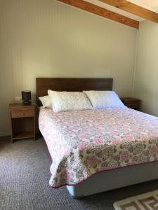 a bedroom with a bed with a pink and white blanket at Rincón del Gaucho in Hornopiren