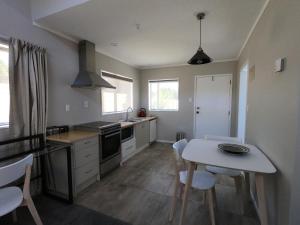 a kitchen with a table and chairs and a kitchen with a stove at The Ohakune Central Motels in Ohakune