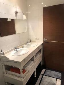 Baño con 2 lavabos y espejo en Apartamento con jardin en Ezcaray