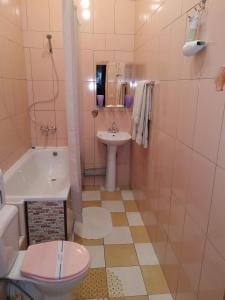 a bathroom with a toilet and a sink and a tub at Yellowunlimited Hotel in Kharkiv
