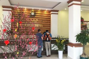 a group of people standing in a lobby with flowers at HAAP Transit Hotel in Noi Bai