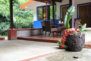a porch of a house with a table and chairs at Horquetas River Lodge in Sarapiquí