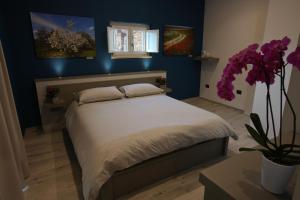 una camera con letto e parete blu di B&B Arco Caputi a Ruvo di Puglia