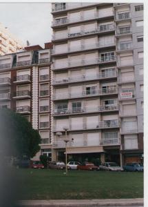 um grande edifício de apartamentos com carros estacionados em frente em Bolivar y Guemes Frente Al Mar em Mar del Plata