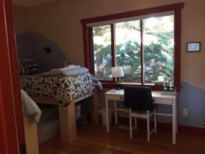a bedroom with a bed and a desk and a window at Sunshine Villa B&B in Madeira Park