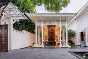 an entry to a house with white walls at 137 Pillars House in Chiang Mai