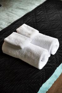 a pair of white towels sitting on a bed at Love Punakaiki Luxury Couples Retreat Limited in Punakaiki
