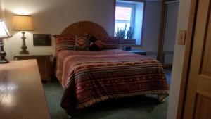 a bedroom with a bed with a blanket and a window at 4047 Wyandot Street in Denver