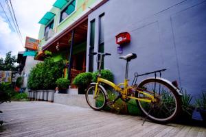 Nap Corner hostel في بيتسانولوك: دراجة صفراء متوقفة أمام مبنى