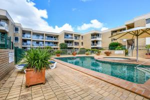 a swimming pool in front of a apartment building at 2 Bedroom Top Floor Unit - Ocean Views and Pool in Alexandra Headland
