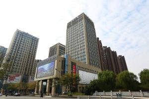 a large building with a large screen in a city at Atour Hotel Hangzhou Jinsha Lake in Hangzhou