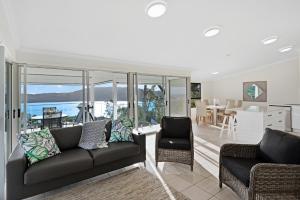 a living room with a couch and chairs and a table at Oasis Apartments on Hamilton Island by HIHA in Hamilton Island