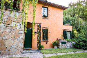 uma casa com uma porta verde e uma parede de pedra em Alquiler temp "UNA PAUSA" Barrio Privado en Vistalba em Mendoza