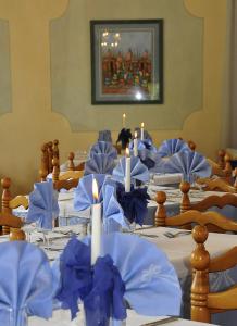 un groupe de tables avec des serviettes bleues et des bougies sur elles dans l'établissement Hotel Florida, à Levico Terme