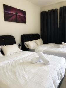 two white beds in a room with black curtains at TREFOIL, WEE 816 STUDIO in Setia Alam
