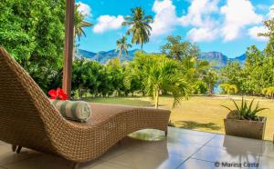a wicker chair on a porch with a view of the mountains at Surf Tropical Villa Takamaka in Cerf Island