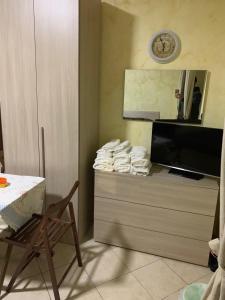 een kamer met een dressoir met een klok aan de muur bij Airport Bedroom House in Catania