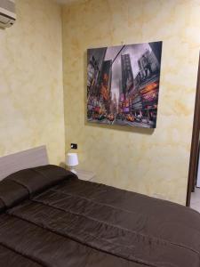 a bedroom with a bed and a painting on the wall at Airport Bedroom House in Catania