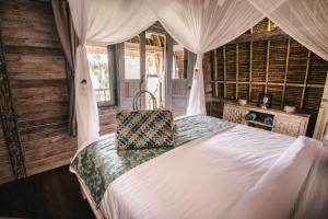 a bedroom with a bed and a canopy at Dream Beach Huts in Nusa Lembongan