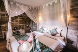 1 dormitorio con 1 cama con sombrero en Dream Beach Huts, en Nusa Lembongan