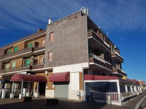 a tall brick building with a balcony at Hotel Torvaianica in Torvaianica