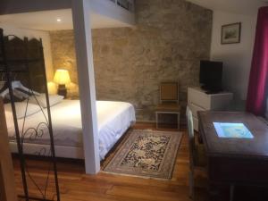 a bedroom with a bed and a table and a television at Chambres d'hôtes La Catounière in Fontainebleau