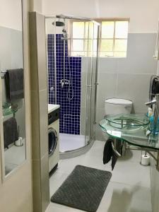a bathroom with a glass table and a shower at MiCasa SuCasa Manor in Pretoria