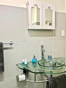a bathroom with a glass sink and a mirror at MiCasa SuCasa Manor in Pretoria
