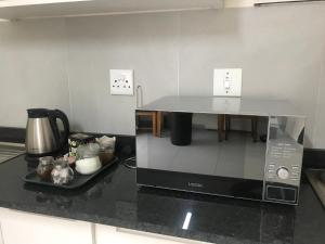 a microwave on a kitchen counter with a table at MiCasa SuCasa Manor in Pretoria