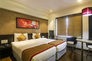 a hotel room with a bed and a table at Hotel LXIA Hinjewadi - Indian Nationals Only in Pune +42 photos