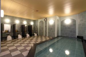 a bathroom with a swimming pool and a tiled floor at Hotel Monte Hermana Sendai in Sendai