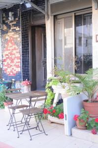 een tafel en stoelen op een veranda met planten bij Ahuzat Shaul - Studio in H̱adera