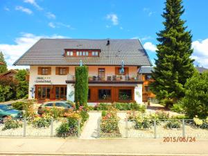 une maison avec beaucoup de fleurs devant elle dans l'établissement Hotel Leonhardihof, à Bad Tölz
