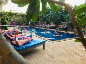 - un groupe de personnes se posant dans une piscine dans l'établissement Blue Diamond Hostel, à Battambang