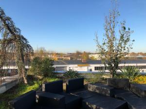 a garden with black chairs and trees and a building at Big Space-Loft in Hannover