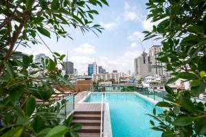 a swimming pool with a city skyline in the background at Hyde Park Hotel Bangkok in Bangkok