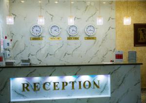um quarto com relógios na parede e um sinal de recepção em Hotel Alash em Astana
